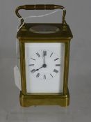 Continental vintage brass carriage clock, white enamel dial with Roman numerals, back plate stamped