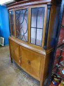 An Irish bow fronted display cabinet having an ebonised column to each side of the top, the base