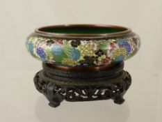 Antique Chinese Cloisonné Bowl, the bowl decorated with brightly coloured flowers, on a hardwood