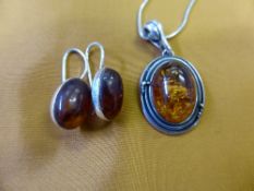 An Amber Pendant on a solid silver chain, together with a pair of earrings.