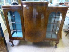 Victorian walnut display cabinet has a bow fronted door to centre with an astral glazed door to each