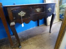 A Georgian antique oak hall table with three drawers on splayed supports, the drawers with brass