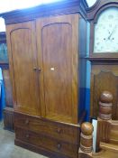 A Victorian mahogany gent`s wardrobe having double doors with tie hanger to the top, the base having