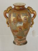 A Japanese Satsuma vase depicting ancestors and dragons with dragon handles, marks to base,