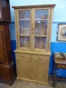 A small pine dresser having glazed top enclosing two shelves, the base having two drawers and