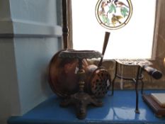 A copper bed warming pan depicting a peacock together with a 19th century copper heater, a wrought