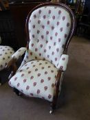 A Victorian mahogany grandmother`s armchair having floral embroidered upholstery