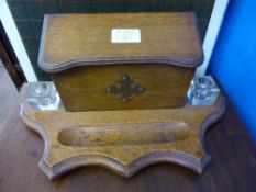 An antique oak stationery stand with two cut glass ink wells.
