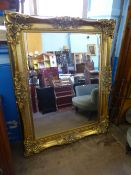 A Large Gilt Wood Mirror, with decorative scroll design to top, bottom and sides, approx 155 x 115