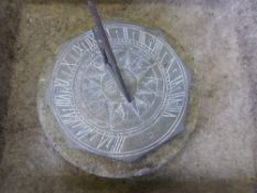 An octagonal brass sundial with a round stone base, approx. 20 x 20 cms.