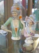 Two porcelain "half doll" figures, the larger one in a green bodice and holding a fan to her