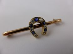 A lady`s 9ct sapphire and diamond horseshoe pin brooch, the brooch set with six graduated old cut