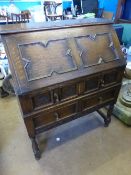 An Edwardian oak bureau, with decorative panelled front, the interior fitted with pigeon holes and