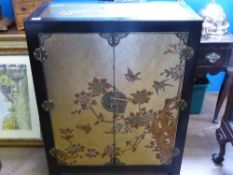 A Chinoiserie ebonised cabinet, the back, front and sides being decorated with Chinese foliage and