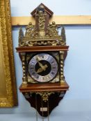 A Dutch open faced brass and mahogany wall clock, the clock having ornate brass decoration, with a