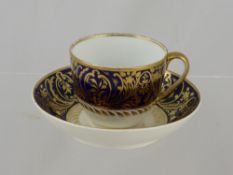 A Royal Crown Derby cup and saucer, blue and white with gilt swirls.