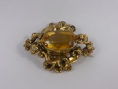 A Lady`s Antique Gold and Citrine Brooch, the oval Citrine set in a floral mount, 18 x 12 mm, total