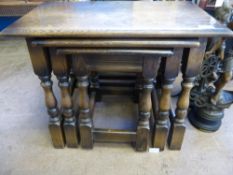 A nest of three oak tables on part turned legs.