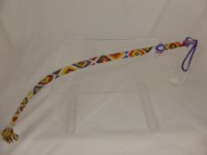 A Vintage Masai Beaded Whip, together with a toasting fork.