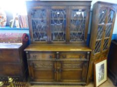 An Old Charm style oak display cabinet, astral glazed doors to the top, two drawers and two