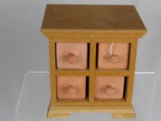 A Miniature Spice Cabinet, with four pottery drawers, 17 x 12 x 17 cms.