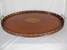 An antique oval Sheraton style butler`s tray having an inlaid shell decoration to the centre and