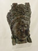 A Bronze Portrait Head of an Indian Temple Goddess with elaborate head dress, contemplative