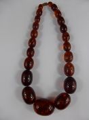 Set of Graduated Oval Amber Beads, the centre bead measures 3 x 2.2 cms, approx 40 cms in length.