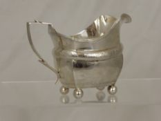 A Solid Silver Georgian Milk Jug, London hallmark, m.m rubbed, circa 1800, supported on ball feet