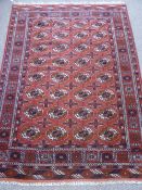 A Vintage Persian Bukhara Rug, cream and terracotta highlights on a soft ruby ground, geometric