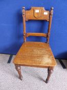 Arts and Crafts oak hall chair being bar back with shield decoration to the top bar.