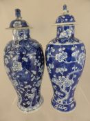 Two Antique Chinese Blue and White Lidded Pillar Vases, the vases depicting blossom, one with