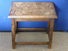 Antique oak stool having carved decoration to the top, the legs being united by stretchers, approx.