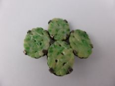 A Chinese green and white jade brooch having four oval carved cameos depicting birds and leaves,