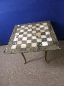 Marble chess / draughts board being supported on a brass four legged base, approx. 50 x 50 x 44