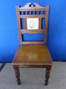 Edwardian mahogany straight back hall chair having a small floral ceramic tile to the back, turned