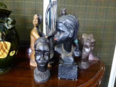 Collection of African tribal carvings including a man playing a harp, a woman grinding corn, three