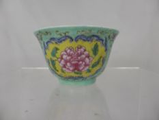 Chinese Porcelain Tea Bowl depicting pink peony on a yellow ground, approx 11 x 7 cms.