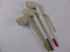 Four clay pipes, one decorated with a claw, another with a boot and ball, another impressed S