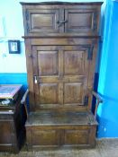 A circa 18th century elm Bacon Settle having a two door panelled top cupboard with single cupboard