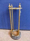 A vintage brass umbrella stand with four finials to the top on cast iron base, approx. diameter of