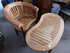 A teak garden armchair being tub shaped by Brambecrest together a kidney shaped teak garden table,