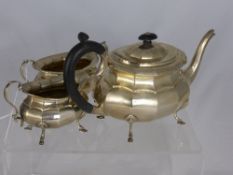 A Solid Silver Tea Trio comprising a tea pot with segmented design, ebony handle and finial on hoof