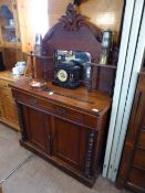 A Victorian mahogany chiffonier having an arched decorated top with two small shelves supported on