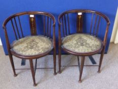 A pair of antique tub armchairs having inlaid banding on turned legs with cross stretcher.