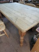 A large pine kitchen table on turned legs, approx. 183 x 112 x 78 cms.