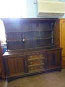 A large 19th century oak dresser, the top having three shelves and panelled back, the base having