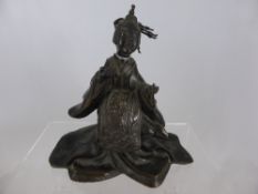 A Japanese bronze figure of a Geisha.  The figure wearing ornate traditional costume with a panel