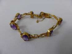 An Edwardian Lady`s 9ct Gold Amethyst and Seed Pearl Bracelet, the bracelet set with seven oval cut