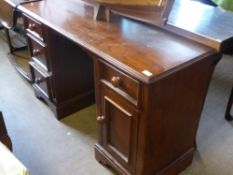 A reproduction Victorian mahogany kneehole desk having three drawers to the left hand side and one